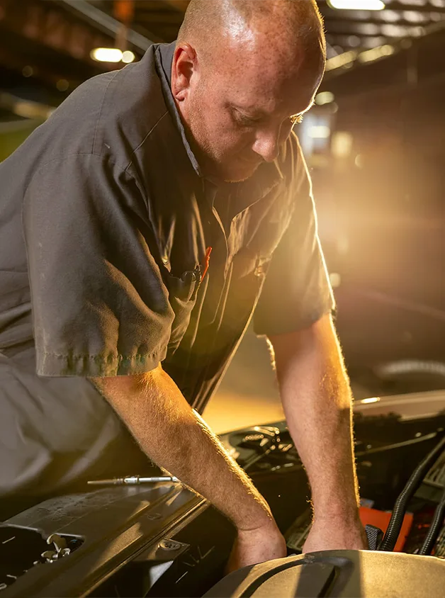 model 1 mechanic working in the engine of a bus